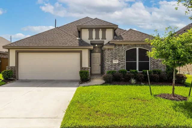 Front exterior — brick and stucco one-story home with a two-car garage