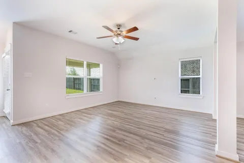 Family room with ceiling fan and natural light