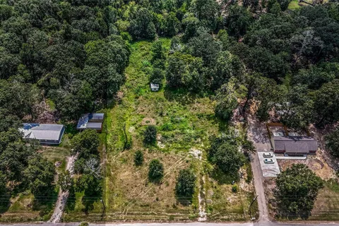 Aerial view of the property and surrounding tree line