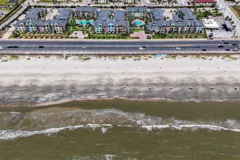 Two pools, mature palms, and Gulf frontage