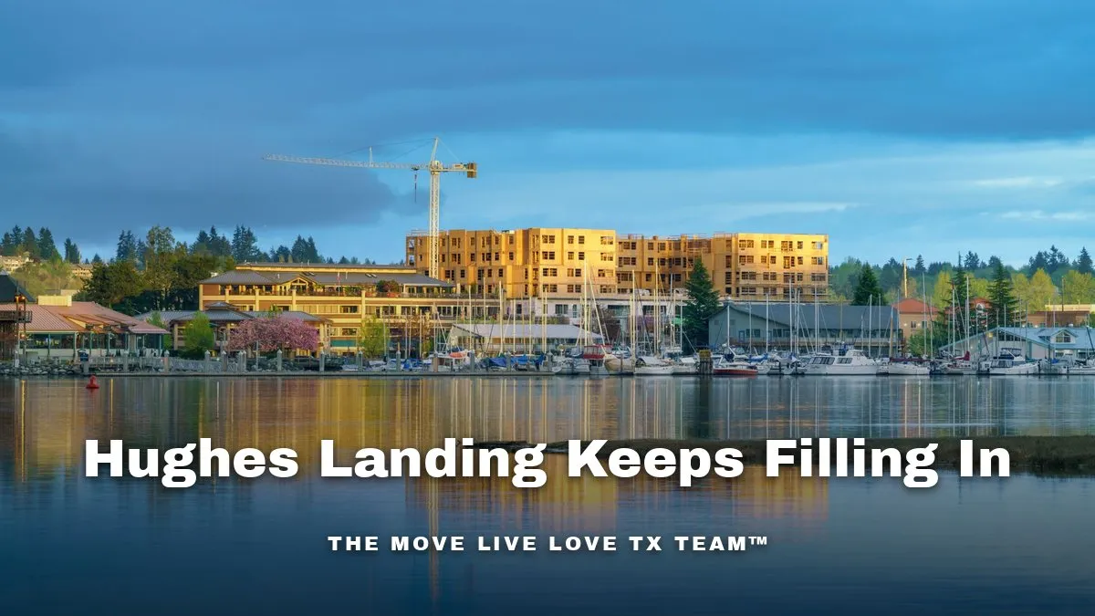 A lakeside mixed-use development with office towers and walking paths in warm afternoon light