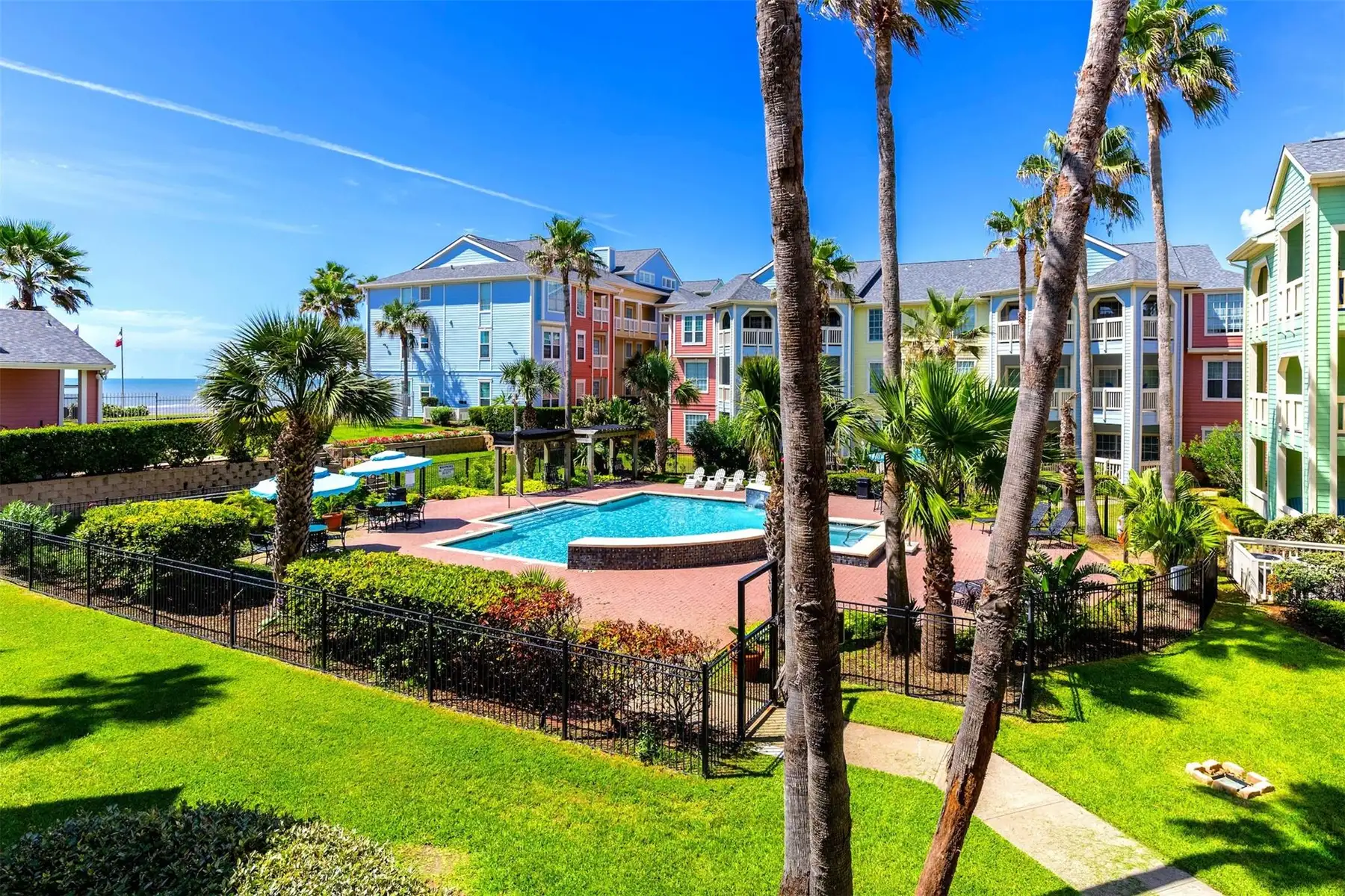 Resort-style pool and courtyard, Gulf beyond — the view from the community
